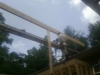 Carpenter setting a ridge beam over a new addition frame — Ice Dam Removal by Roofing Brothers in Mount Holly