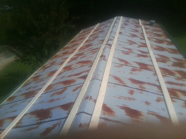 Rusted metal roof panels with new wood purlins before replacement — Storm Damage Roof Repair in Mount Holly by Roofing Brothers
