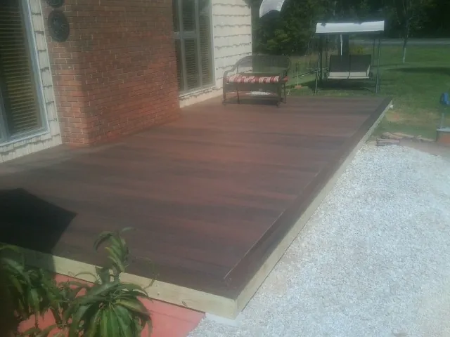 Freshly stained wood deck built against a brick home in Mount Holly